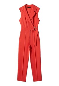 Combinaison rouge sans manches avec col à revers, taille ceinturée avec une boucle argentée, et pantalon droit sur fond blanc.
