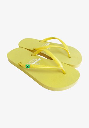 Chanclas amarillas con suelas texturizadas, tiras delgadas amarillas y un acento de la bandera brasileña en verde. Diseño simple y plano sin patrones adicionales.