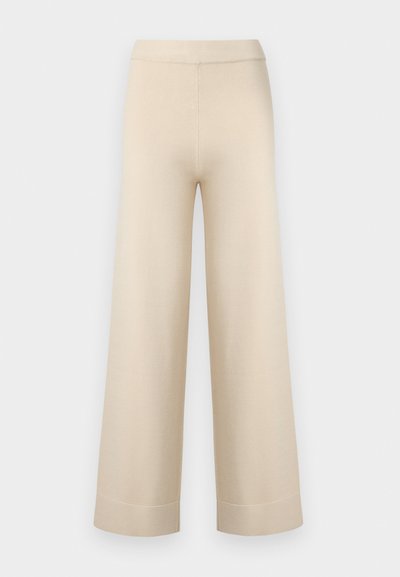 Μπεζ παντελόνια με φαρδιά μπατζάκια, ψηλή μέση και ρεβέρ στο τελείωμα, αποτυπωμένα σε απλό ανοιχτό γκρι φόντο.