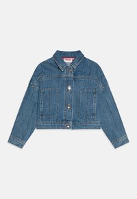 Kuttet denimjakke i lys blå med spiss krage, sølvknapper foran, to forsidelommer og dekorativ søm langs skuldrene.