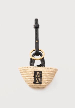 Kleine gewebte Strohtasche mit schwarzen Ledergriffen, schwarzem Riemen und goldfarbenem Ringdetail, hängend vor hellem Hintergrund.