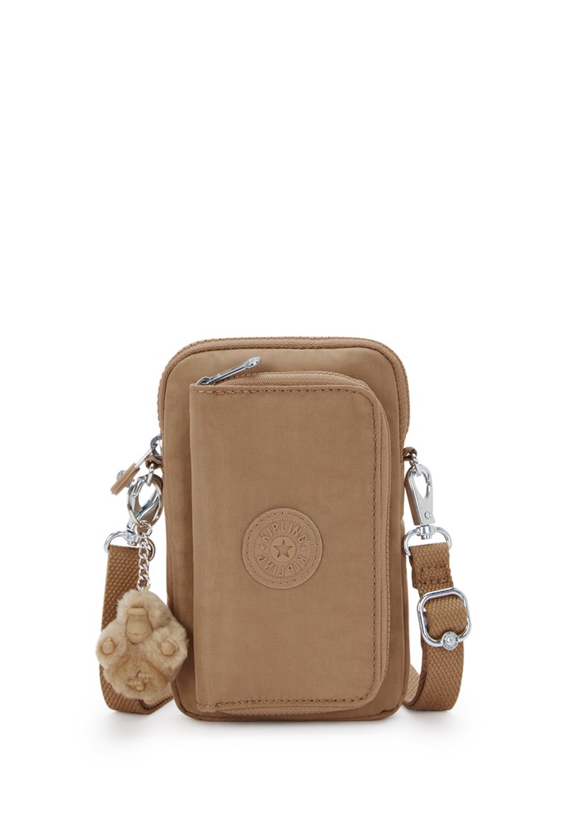 Borsa a tracolla piccola color beige con tasca frontale con cerniera, patch del logo Kipling, tracolla regolabile e un portachiavi a forma di scimmietta in peluche attaccato.