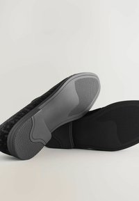 Mustriselt mustad libisemisjalanõud kummist tallaga; talla pinnal on pidamise muster ja sujuv hall aktsent kandmisel.