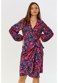 Květinové šaty s volným rukávem v tmavě modré barvě s růžovými a červenými vzory listů, dlouhé rukávy a detail vázání v pase. Hladká, lehká tkanina.