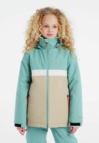 Tealte en beige skijack met een hoge kraag, ritssluiting, zijzakken en een contrasterende witte streep. Gemaakt van een gladde, waterdichte stof.