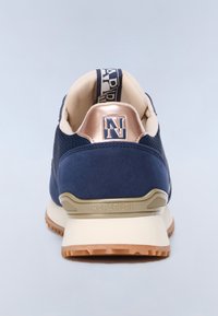 Baskets bleu marine avec accents au talon beige et or rose, doublure intérieure beige, languette de tirage avec logo, et semelle extérieure en caoutchouc marron texturée.