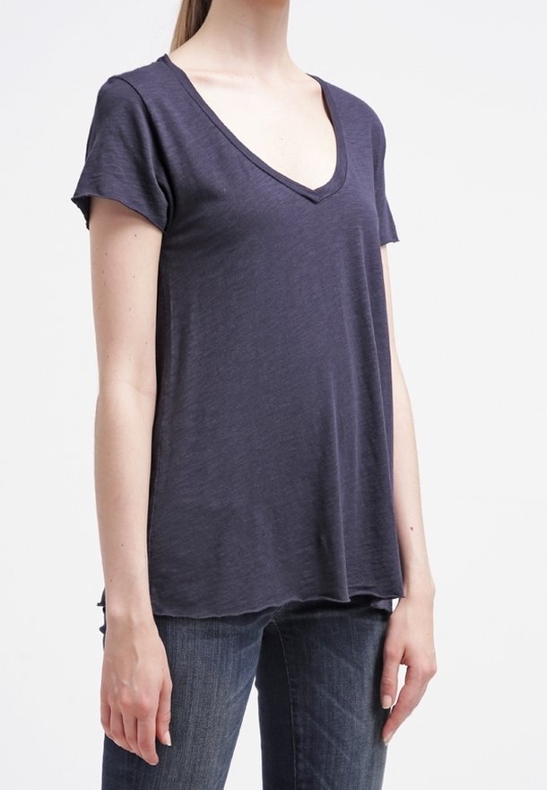 Námořnická modrá tričko s výstřihem do "V" vyrobené z lehké tkaniny, s krátkými rukávy a volným střihem, má jemnou strukturu a boční rozparky.