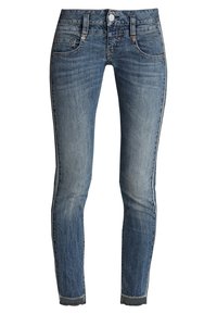 Slim-fit blå denimjeans med en blekt finish, fem fickor och en fransad fåll. Funktioner inkluderar knäppning och bälteshällor.