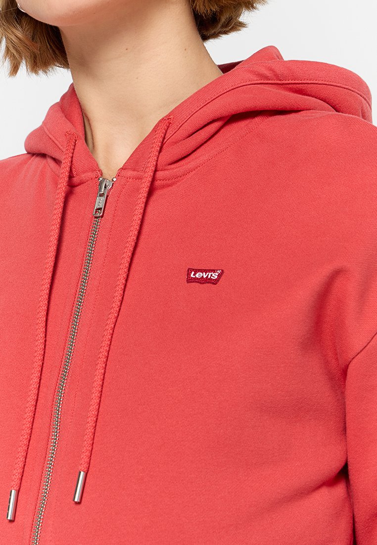 Felpa rossa con zip e cordini, caratterizzata da un piccolo logo ricamato di Levi's sul petto. Realizzata in un tessuto morbido e strutturato.