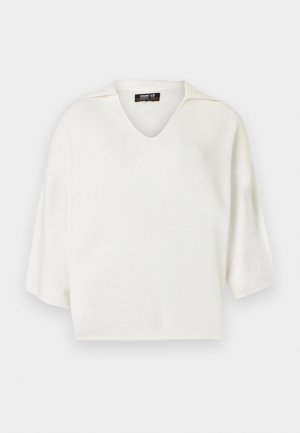 Valge V-kaelusega kudum, millel on lühikesed varrukad ja mugav lõige. Sile tekstuur, minimalistlik disain ja ilma nähtavate kaunistusteta.