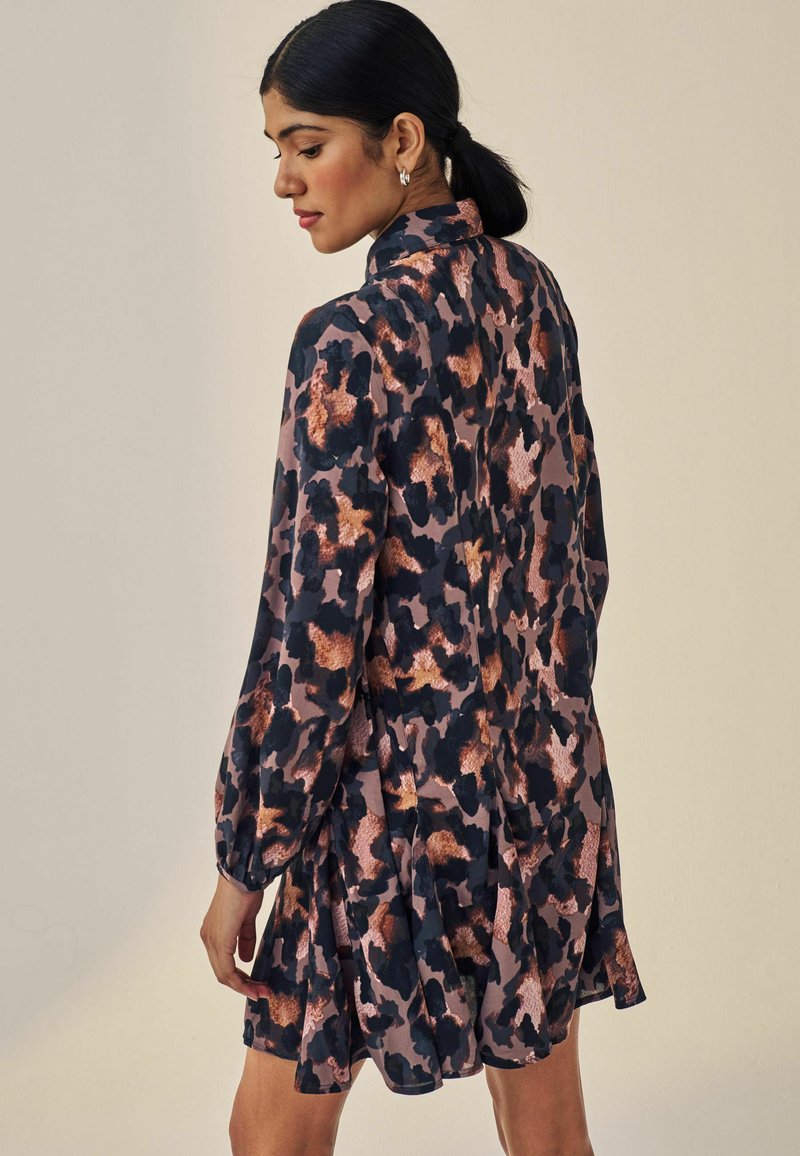 Leopardenmusterkleid in dunklen Tönen mit rosa und kupferfarbenen Akzenten, featuring einen hohen Kragen und lange Ärmel, sowie einen fließenden, gestuften Rock.