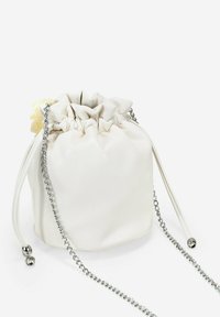 Bolso de tiro de cuero sintético blanco con una parte superior fruncida, tira de cadena plateada y un acento decorativo amarillo en el lateral.
