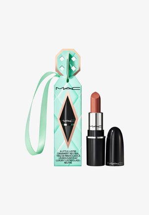 Rossetto MAC in tonalità nude con tappo nero accanto a una scatola ornamentale a motivi diamante color teal con un nastro arrotolato per appendere.