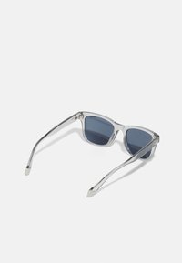 Ochelari de soare cu ramă transparentă, lentile de culoare albastru închis, design unghiular și brațe subțiri. Au accente din metal pe tampla pentru un plus de detaliu.