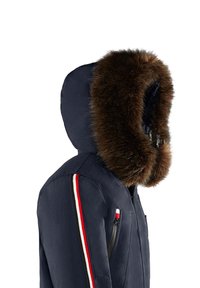 Marinskjorta med en stor brun pälskantad huva, med en dragkedjeförsedd bröstficka och röd, vit och blå randiga detaljer på ärmen.