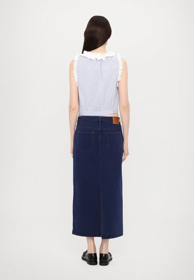 Blauw en wit geruit crop top met een ruffles kraag, gecombineerd met een donkerblauwe denim midi rok met een achterste split en patch zakken.