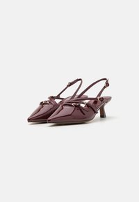 Burgundy patento nahka slingback korkokengät, joissa on terävä nenä, kapeat hihnat ja pieni loiva korko. Sisältää koristeellisia metalliosia.