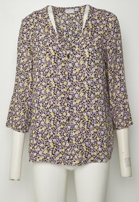 Blusa com padrão floral, de mangas três quartos, fundo preto, com pequenas flores amarelas e lavanda, decote em V, frente com botões.