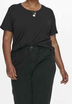 Sort bomuldst-shirt med opkavlede korte ærmer, kombineret med sorte jeans med elastik i taljen, sidelommer og knaplukning.