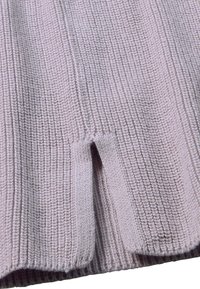 Helllila gerippter Strickstoff mit einem kleinen Schlitzöffnungsnahe der unteren Kante, der Struktur und ein vertikales Strickmuster zeigt.