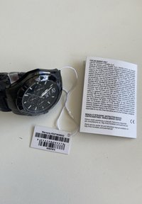 Orologio cronografo nero con finitura lucida, dotato di quadrante rotondo e marcatori numerici. Include un tag di garanzia e un manuale di istruzioni.