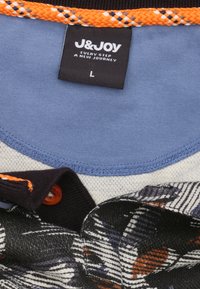 Gelaagd topje met een blauwe zachte stoffen kraag, zwart gestructureerd stof met een patroon en een oranje gevlochten accent. Voorzien van een label met de markering "L."