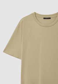 T-shirt beige a maniche corte in cotone con scollatura rotonda, taglia XXL, etichetta del marchio "CALLIOPE" visibile sul colletto.