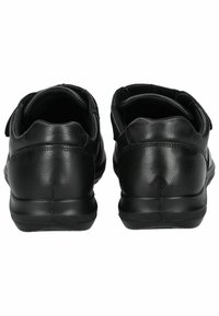 Sorte lædersko med en glat tekstur, rund ryg og flade gummisåler. Velcro-stropper til lukning. Subtile sømdetaljer.