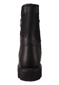 Botín negro con un exterior de cuero suave, paneles laterales de malla texturizada, suelas robustas y un acento decorativo de metal.