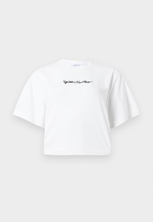 Witte, korte crop-top met korte mouwen en zwarte cursieve tekst centraal op de borst, tegen een effen achtergrond.