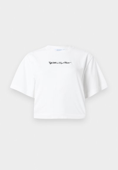 Λευκό κοντομάνικο κοντό t-shirt με μαύρη γραφή σε καλλιγραφικό στυλ, κεντραρισμένη στο στήθος, μπροστά σε απλό φόντο.