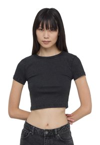 Cropped t-shirt nera a coste con maniche corte e scollatura rotonda. Il tessuto presenta una finitura texture e dettagli di cucitura visibili.