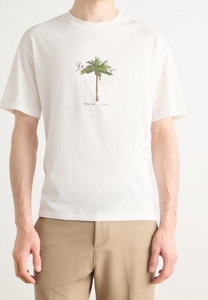 Witte katoenen t-shirt met een groene palmbomenafbeelding in het midden, met daaronder zwarte tekst. Korte mouwen en een ontspannen pasvorm.