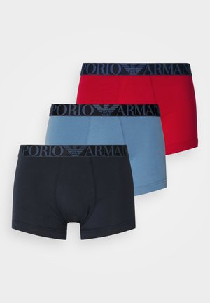 Trois paires de boxers en rouge, bleu clair et bleu foncé. Tous présentent des ceintures élastiques noires de marque avec le logo "EMPORIO ARMANI".