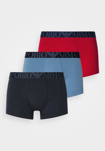 Tres pares de bóxers en rojo, azul claro y azul oscuro. Todos presentan cinturillas elásticas negras con la marca "EMPORIO ARMANI".