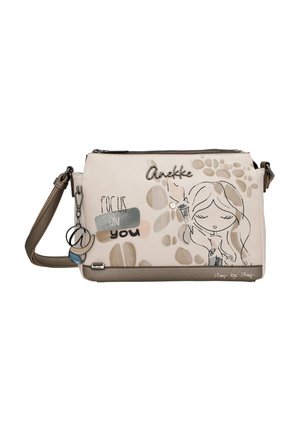 Borsa a tracolla beige con illustrazione di una ragazza, testo "Focus on you", portachiavi decorativi e tracolla marrone regolabile.