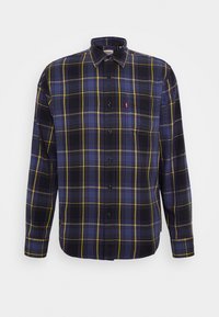 Chemise à carreaux présentant des tons bleus, noirs et jaunes, avec un design à boutons-pression et le logo Levi's sur la poche poitrine. Matière en coton.
