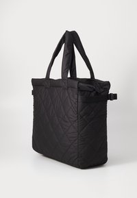 Sac fourre-tout noir matelassé avec deux poignées solides, présente une ouverture en haut et une sangle latérale pour une fermeture ajustable. Tissu lisse et texturé.