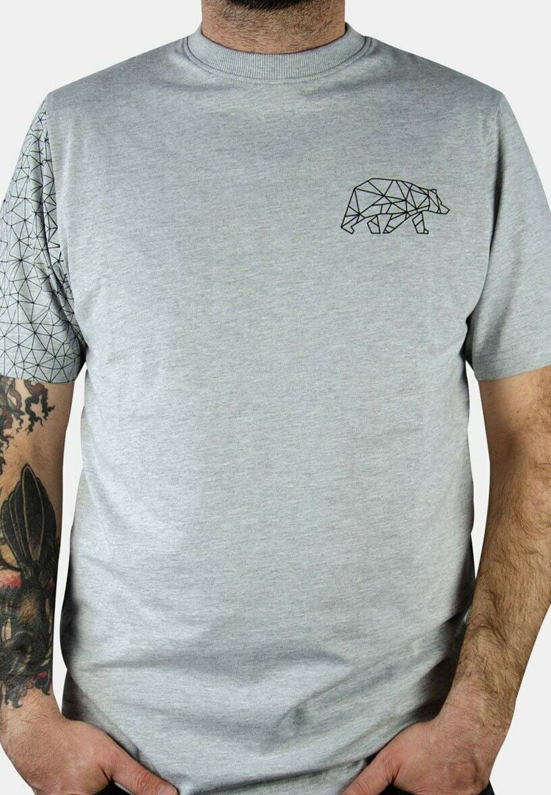 Camiseta gris de manga corta con un diseño de oso geométrico en el pecho y una manga con un patrón de motivo triangular.