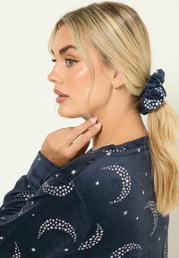 Felpa blu navy con motivi di luna e stelle, texture morbida e maniche lunghe. Accompagnata da un foulard elastico coordinato con design stellato.