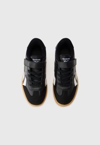 Svarta sneakers med en kombination av läder och meshmaterial. Har snören, ett kardborreband och vita detaljer med en gummigummisul.