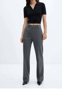 Sort cropped polo-shirt med korte �ærmer, parret med grå højtaljede bukser med knaplukning og vide ben. Sorte spidse sko.