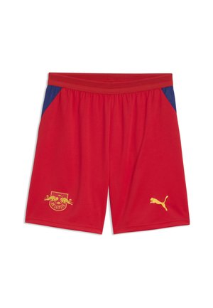 Czerwone krótkie spodenki sportowe z niebieskimi panelami bocznymi, elastyczną talią, logo RB Leipzig na lewej nodze oraz żółtym logo Puma na prawej nodze.