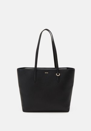 Zwarte leren tote tas met twee lange handvatten, goudkleurig "BOSS"-logo aan de voorkant en een kleine gouden ringdetail aan één handvat.