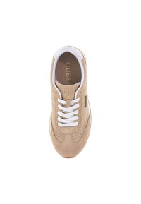 Beige suède sneaker met witte veters, gestructureerd oppervlak, ronde neus en gouden hardware-accent. "GUESS" logo gedrukt op de binnenzool.
