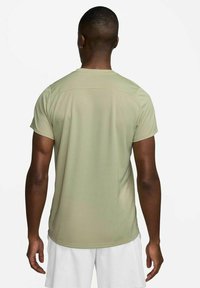Short-sleeved, light olive green athletic shirt, featuring a smooth texture and simple design with a crew neckline.