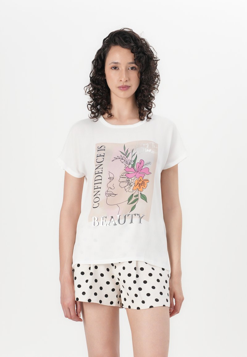 White graphic t-shirt featuring a floral design and metallic text "CONFIDENCE IS BEAUTY." Paired with polka dot shorts. Soft fabric, relaxed fit.