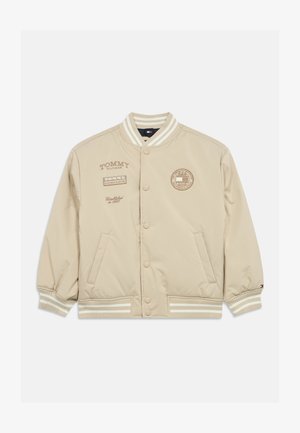 Beige bomber jacket with snap buttons, ribbed cuffs and hem. Features printed logos on the chest and sleeves, made of smooth fabric.
