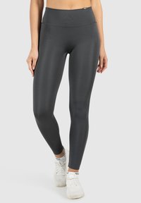 Legginsy o wysokim stanie, dopasowane, w ciemnoszarym kolorze, wykonane z elastycznego, teksturowanego materiału. Posiadają gładki pas w celu zwiększenia komfortu.