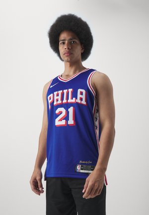 Blue basketball jersey with red accents, features “PHILA” and number “21” in white. Side panels have stars. Made of breathable mesh fabric.